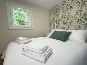 a bedroom with a bed with towels on it at As Cortiñas, casa vacacional completa en Laxe 