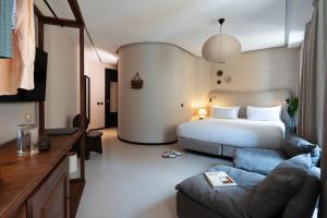 a hotel room with a bed and a couch at Casa Teva Lisboa Boutique Hotel by chic&basic in Lisbon