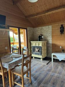 a dining room with a fireplace and a table and chairs at Domki nad morzem - Wisełka in Wisełka