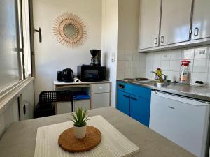 una pequeña cocina con una mesa con una planta en Studio - Arc En Ciel 1 - 23 allée des pinons - 5-1, en Saint-Jean-de-Monts 4 fotos más