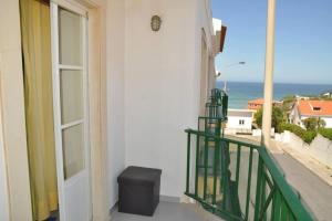 a balcony with a door and a view of the ocean at Casa Anabela - Beach Apartment in Lourinhã