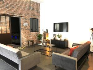 a living room with two couches and a brick wall at l'atelier Charnay in Charlieu