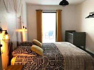 a bedroom with a bed and a window with a chair at l'atelier Charnay in Charlieu