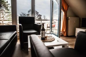 ein Wohnzimmer mit einer Flasche Wein auf einem Tisch in der Unterkunft Dünenglück, Ferienwohnung 33 in Cuxhaven
