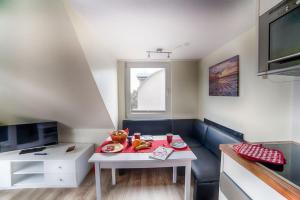 ein kleines Wohnzimmer mit einem Tisch und einem Schreibtisch in der Unterkunft Dünenglück, Ferienwohnung 33 in Cuxhaven