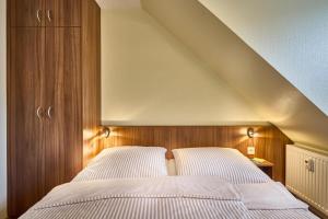ein Schlafzimmer mit einem Bett mit einem hölzernen Kopfteil in der Unterkunft Dünenglück, Ferienwohnung 33 in Cuxhaven