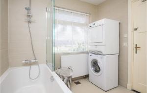 a bathroom with a tub and a washing machine at 'T Sterntje in Bergen aan Zee