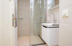 a white bathroom with a shower and a sink at 'T Sterntje in Bergen aan Zee