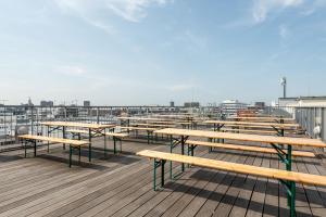 a row of wooden benches on a deck at a&o Hamburg City in Hamburg