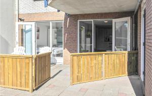 a porch with a wooden fence and sliding glass doors at Zeekalfje in Bergen aan Zee