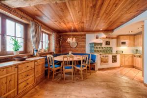 a kitchen with a wooden ceiling and a table with chairs at Ferienhaus Grabenhäusl in Grossarl