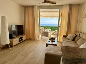 ein Wohnzimmer mit Sofa und Fernseher in der Unterkunft Casa Oceanico Los Gigantes in Acantilado de los Gigantes