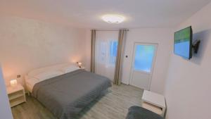 Un dormitorio con una cama y una ventana y una puerta. en Pescarul Deltei, en Murighiol