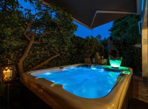 a jacuzzi tub in a backyard at night at Spa Garden Lounge in Mali Lošinj