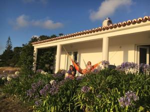 two women sitting on the porch of a house at Arneiro de Valverde - Nature & Magical Sunset in Odemira