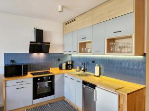 a kitchen with white cabinets and wooden counter tops at Apartament Sand&Blue z basenem in Sztutowo