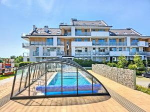a building with a swimming pool in front of a building at Apartament Sand&Blue z basenem in Sztutowo