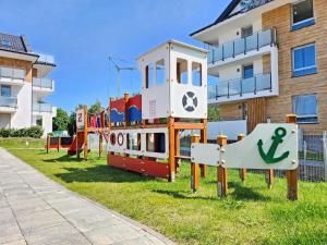 a playground in the grass in front of a building at Apartament Sand&Blue z basenem in Sztutowo