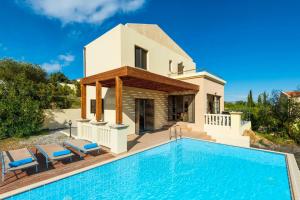 a villa with a swimming pool in front of a house at Villa Athina in Kalathos