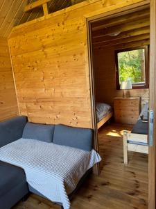 a room with a bed in a wooden cabin at Domki nad morzem - Wisełka in Wisełka