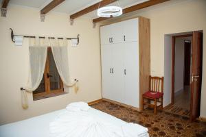 um quarto com uma cama, uma janela e uma cadeira em Vila Beleri 