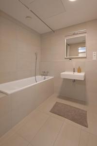a bathroom with a tub and a sink and a mirror at SKAU Sky Park Green by Zaha Hadid 22 floor 1 Tower Panoramic View Free Parking in Bratislava +30 photos