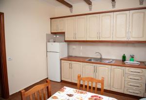 uma cozinha com um frigorífico branco, uma mesa e cadeiras em Vila Beleri 