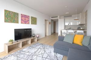 a living room with a blue couch and a television at SKAU Sky Park Green by Zaha Hadid 22 floor 1 Tower Panoramic View Free Parking in Bratislava
