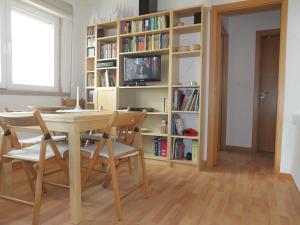 a dining room with a table and chairs and a book shelf at Mar de Sesimbra in Sesimbra