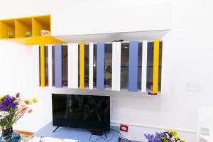 a room with a television and a shelf with a keyboard at Teulada cozy flat with pool and beach access in Teulada
