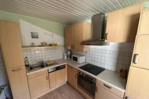 a small kitchen with wooden cabinets and a sink at Monteurzimmer an der Schlei in Rabenkirchen-Faulück