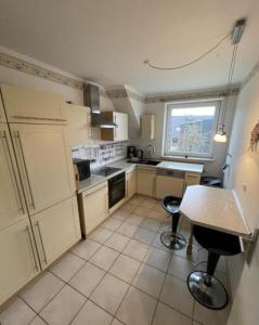 a kitchen with a table and two stools in it at Monteurzimmer an der Schlei in Rabenkirchen-Faulück