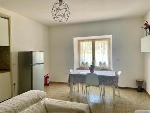 a kitchen with a table with chairs and a refrigerator at DAL ZARO HOME in Scandolara Ravara