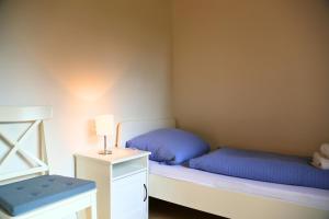 a small bedroom with two beds and a night stand at Monteurzimmer bei Kappeln in Rabenkirchen-Faulück