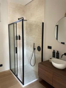 a bathroom with a glass shower and a sink at Le Boulevard Suites & Apartments in Olbia