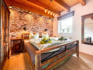 una cama en una habitación con una pared de ladrillo en Dat Fleetenkiekerhus 2, en Hage