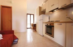 a kitchen with white appliances and a living room at Beautiful Apartment In Costa Rei -Ca- With Wifi in Monte Nai