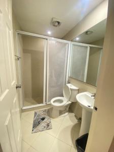 a bathroom with a shower and a toilet and a sink at Townhouse Mellow Yellow D#220 3storey 120sqm in Batangas City
