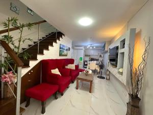 a living room with a red couch and a staircase at Townhouse Mellow Yellow D#220 3storey 120sqm in Batangas City