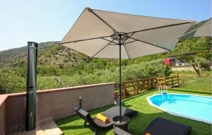 an umbrella and chairs next to a swimming pool at Lovely Home In Avella in Avella