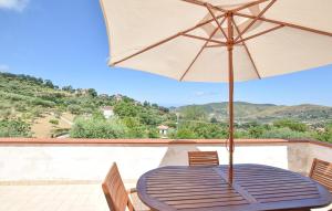 a table with an umbrella on a balcony at Nice Home In Perdifumo in Perdifumo