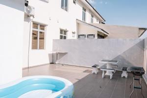 a backyard with a pool and a table and a grill at Spacious 4-Bedroom Family Home Near Senai JB in Kampung Seelung