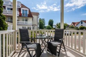 een terras met twee stoelen en een tafel op een balkon bij App Osiria in Kühlungsborn