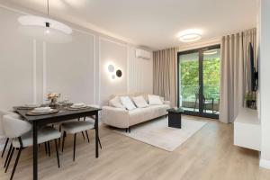 ein Wohnzimmer mit Tisch und Couch in der Unterkunft Luxury Apartment with Parking and Air Conditioning in Sopot by Renters Prestige in Sopot