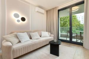 ein Wohnzimmer mit Couch und großem Fenster in der Unterkunft Luxury Apartment with Parking and Air Conditioning in Sopot by Renters Prestige in Sopot + 15 Fotos