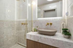 ein Badezimmer mit Waschbecken und Dusche in der Unterkunft Luxury Apartment with Parking and Air Conditioning in Sopot by Renters Prestige in Sopot