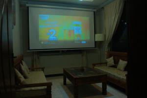 a projection screen in a living room with two chairs at Mountain Chalet in Naka