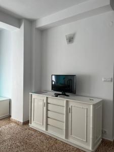 Biała szafka z telewizorem na górze w obiekcie Mariola w mieście Calpe