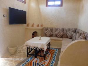 a living room with a couch and a tv at Elhamma Resort Studio in Tozeur