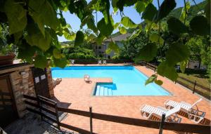a swimming pool with two lawn chairs at Cozy Apartment In Montemonaco in Montemonaco